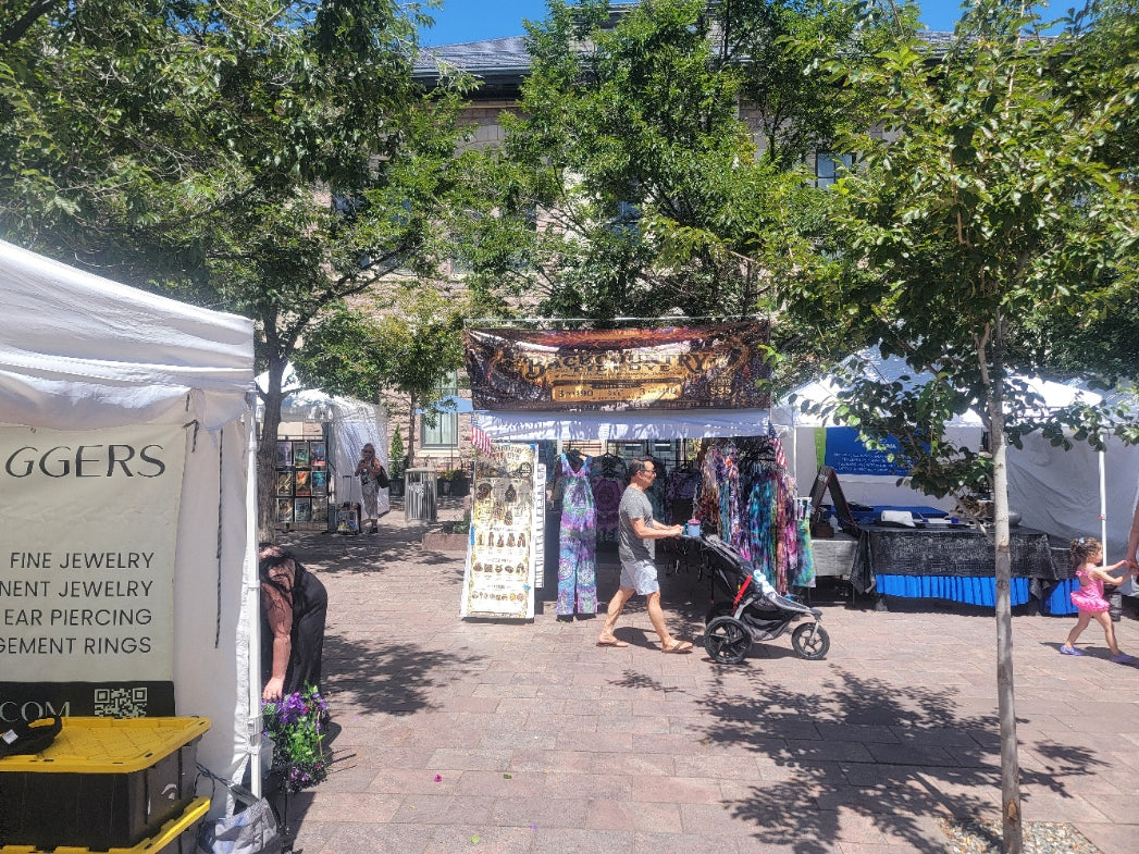 Outdoor market booth with tents and shoppers